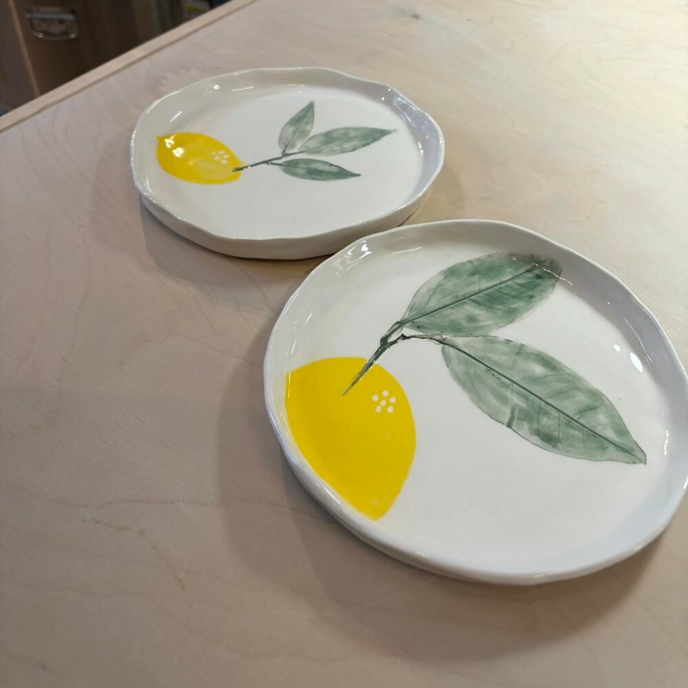 Δύο χειροποίητα πιάτα ζωγραφισμένα με λεμόνια, δημιουργίες που ξεχωρίζουν στα μαθήματα κεραμικής του εργαστηρίου μας Theta for Ceramics στου Ζωγράφου.